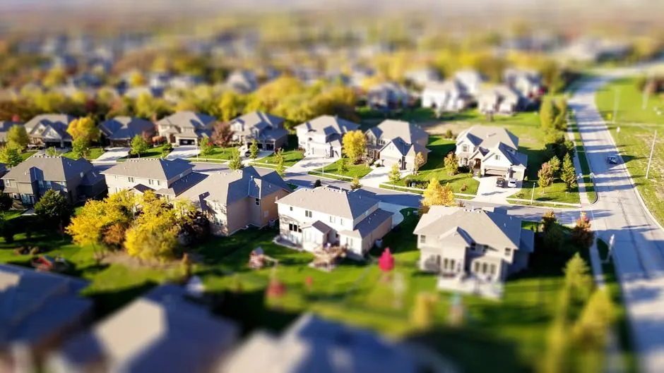 Aerial view of a residential neighborhood with houses along tree-lined streets, illustrative image